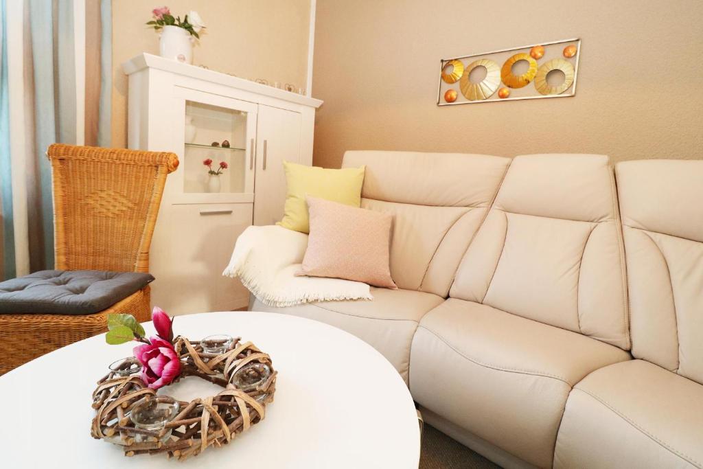 un soggiorno con divano bianco e tavolo di Heydens Ferienhaus_HEYD a Ostseebad Karlshagen