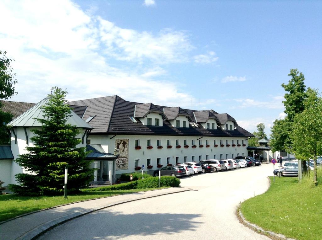 un gran edificio blanco con muchos coches aparcados en 1A Landhotel Schicklberg, en Kremsmünster