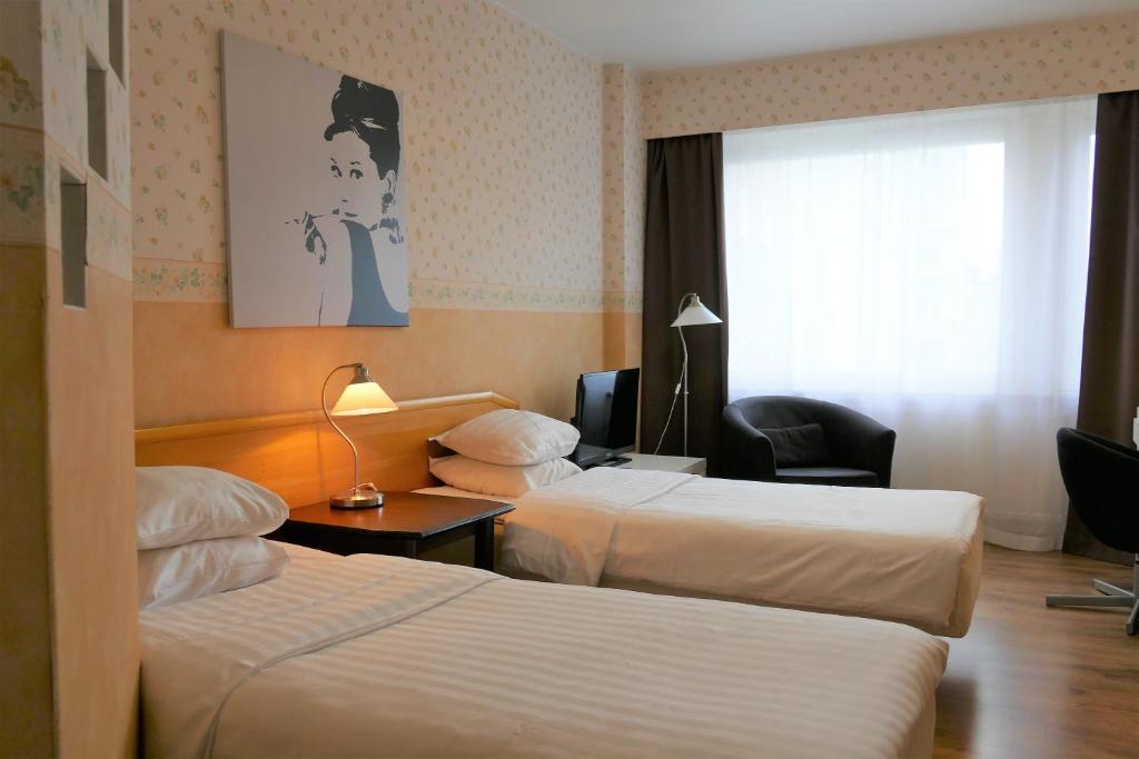 Habitación de hotel con 2 camas y ventana en Linnanpiha Bed & Breakfast en Rauma