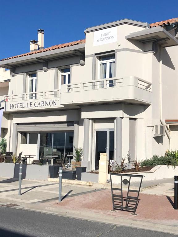 a hotel le cameron building on the corner of a street at Hôtel Le Carnon in Carnon-Plage