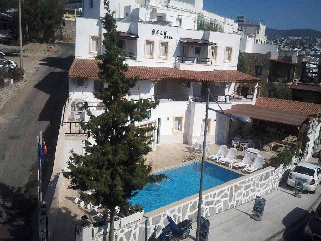 a building with a swimming pool in front of a building at Cam Hotel in Gümbet