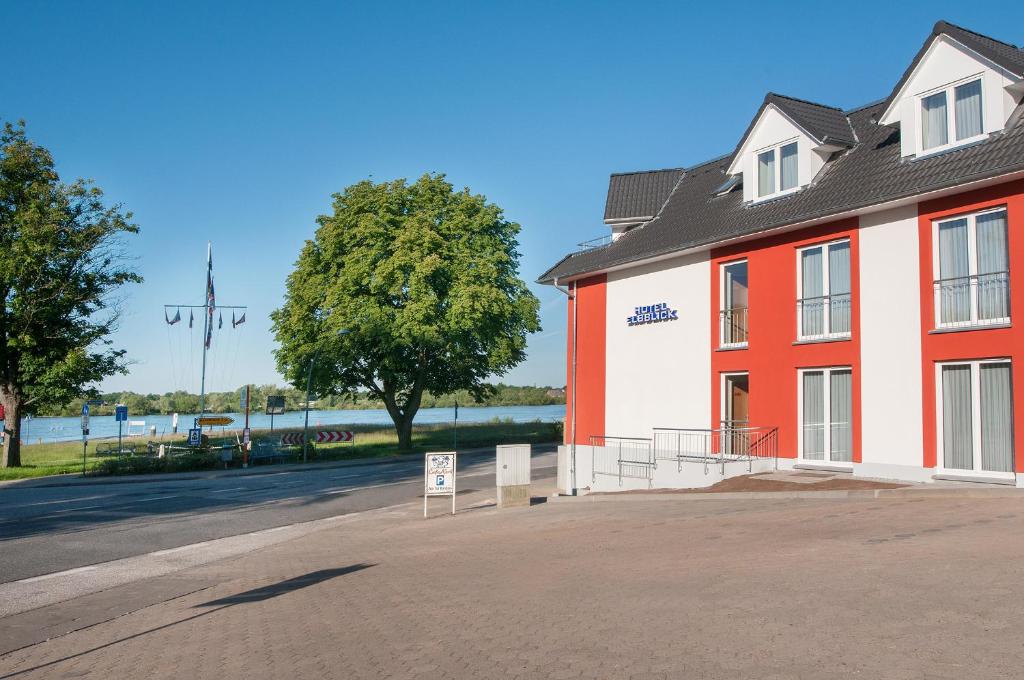 un bâtiment rouge et blanc sur le côté d'une rue dans l'établissement Hotel Elbblick, à Geesthacht