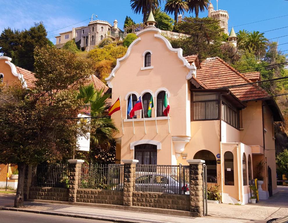 a pink house with flags on top of it at Aquamarina Apart Hotel in Viña del Mar