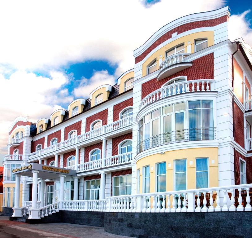 un gran edificio rojo y blanco con balcón en Hotel Grand Palace en Svetlogorsk