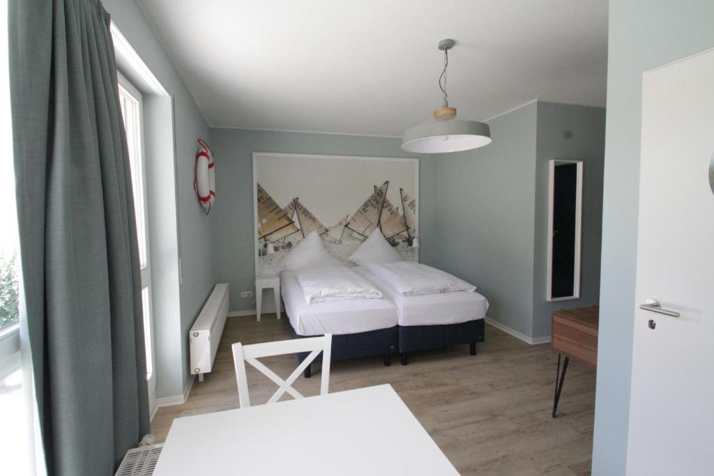 ブランデンブルク・アン・デア・ハーフェルにあるHavelhotelのベッドルーム1室(白いベッド2台付)