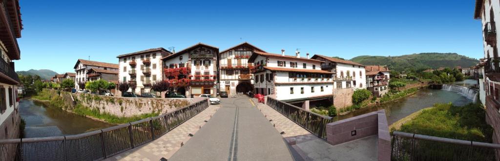 a bridge over a river in a town with buildings at Hostal Trinkete Antxitonea in Elizondo