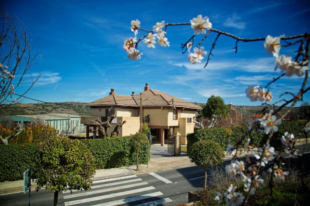 ein Haus mit einem blühenden Baum davor in der Unterkunft Villa Castro in Nuévalos