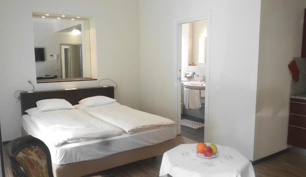 a bedroom with a bed and a sink and a mirror at Hotel Federale in Lugano