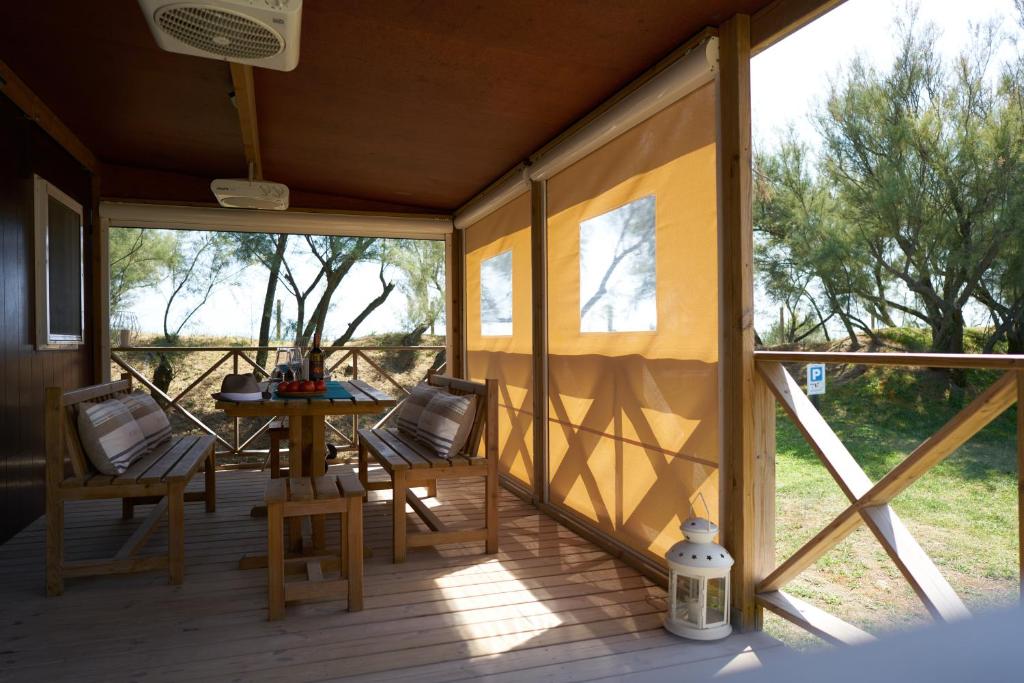 a screened in porch with a table and chairs at Camping Lido in Bibione