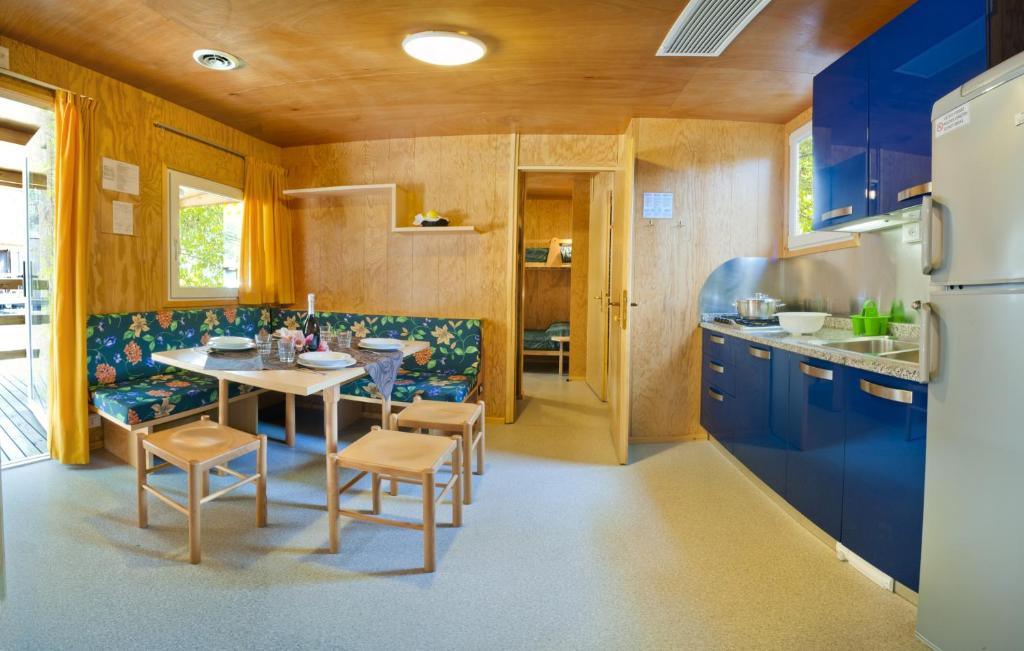 a kitchen with blue cabinets and a table and chairs at Camping Lido in Bibione