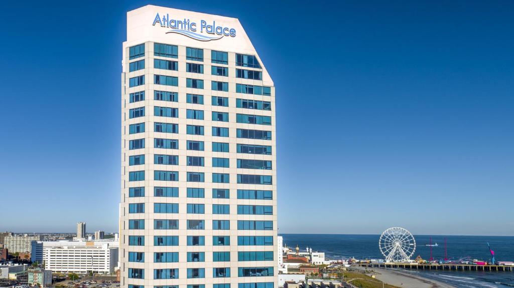 Um edifício alto e branco com uma placa de palácio atlântico. em Boardwalk Resorts at Atlantic Palace em Atlantic City