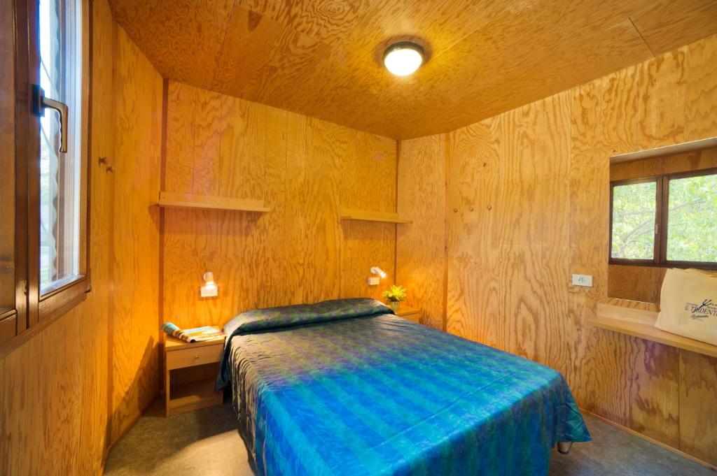 a bedroom with a bed in a wooden room at Camping Lido in Bibione