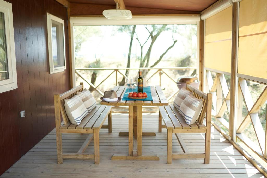 a wooden table and two chairs on a porch at Camping Lido in Bibione