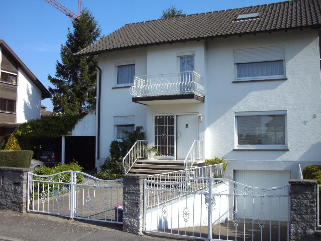 une maison blanche avec une clôture blanche devant elle dans l'établissement Engel Ringsheim, à Ringsheim