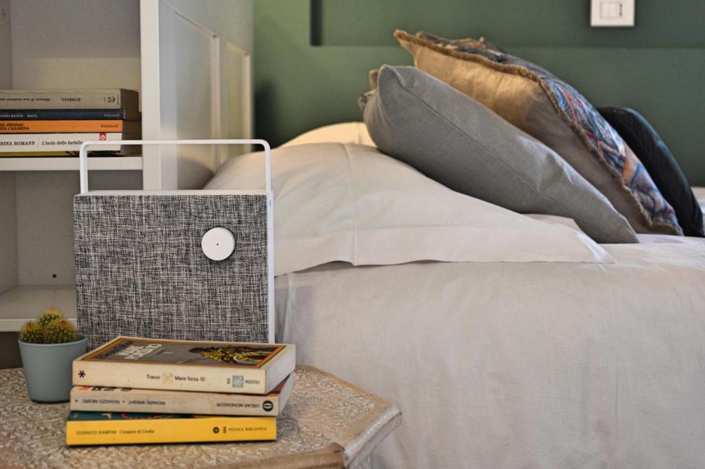 a bed with books on a table next to a bed at Casa Mysa - Apartment in Costa di Mezzate