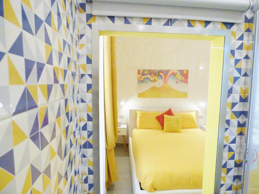 een kleine slaapkamer met een bed en een spiegel bij B&B Lemon Flats in Napels