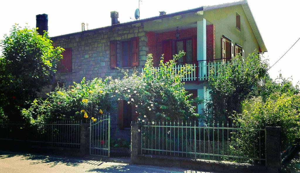 une maison en briques avec une clôture devant elle dans l'établissement Appartamento Degli Dei (Affittacamere), à Madonna di Fornelli