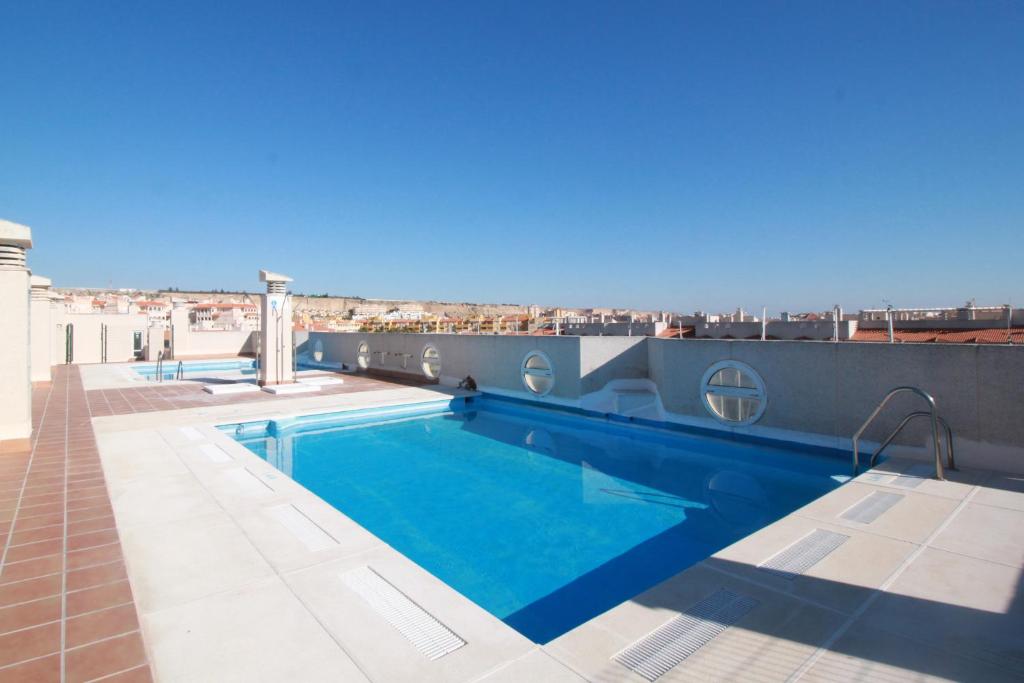 a swimming pool on the roof of a building at Expoholidays - Apartamentos Puerto Almerimar in Almerimar