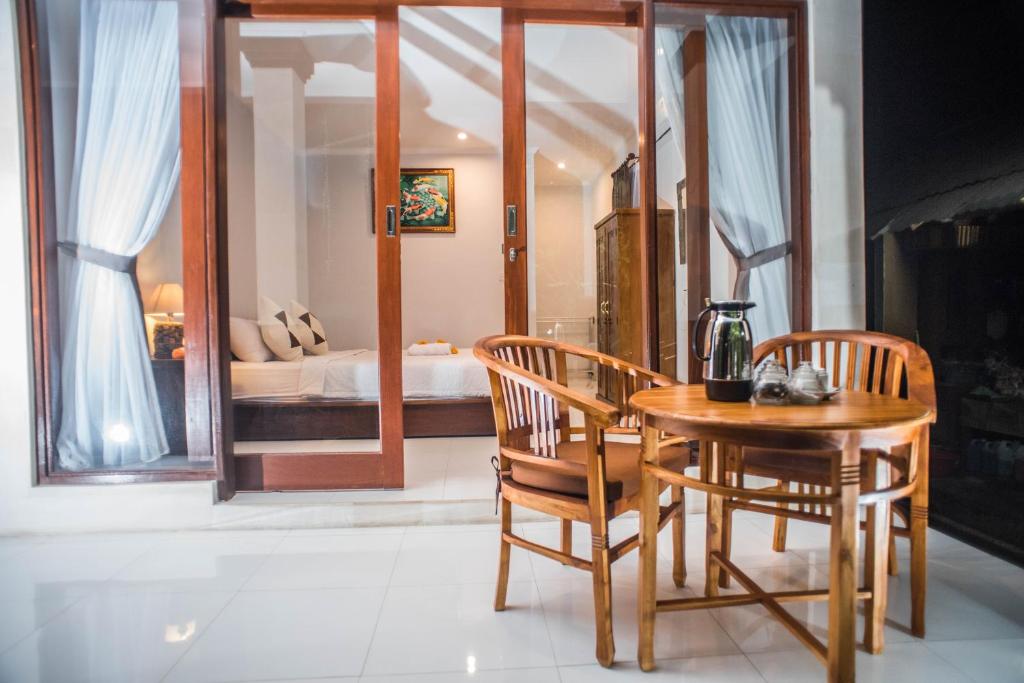 a dining room with a table and chairs and a bedroom at Suntari Homestay in Ubud