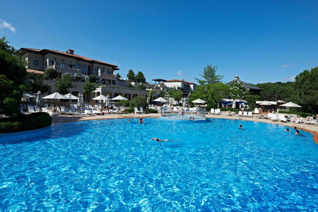 a group of people swimming in a large swimming pool at Kemer Country Hotel İstanbul in Istanbul