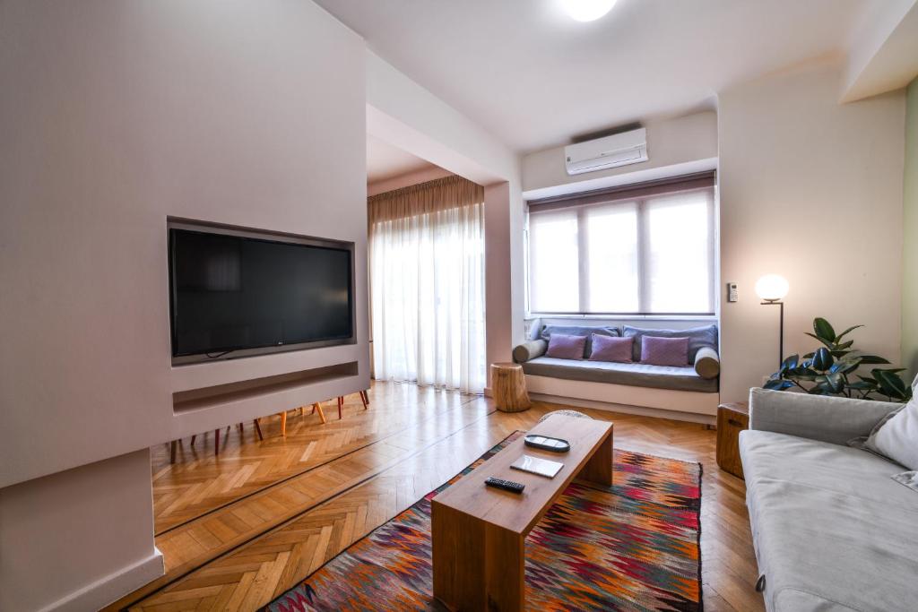 a living room with a couch and a tv at Kolonaki Boutique Apartments by Olala Homes in Athens