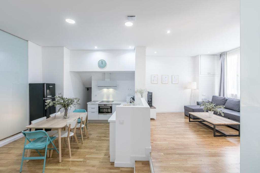 a kitchen and living room with a table and chairs at Loft Candela in Seville