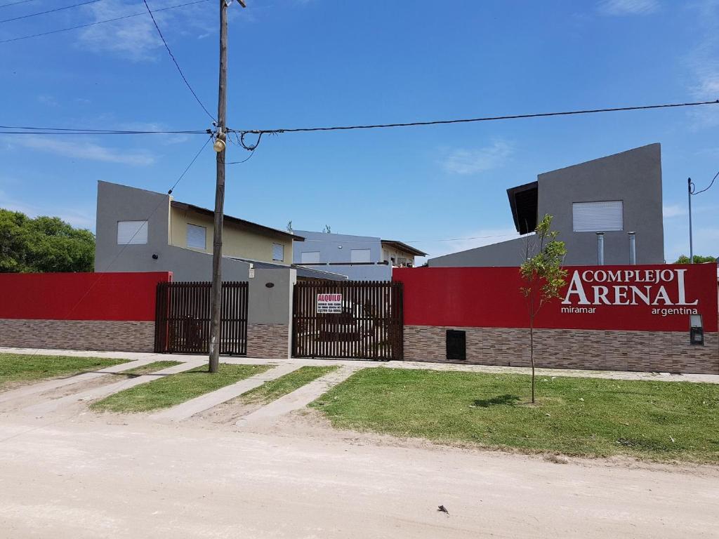 ein rot-weißes Gebäude mit einem Schild darauf in der Unterkunft Complejo Arenal in Miramar
