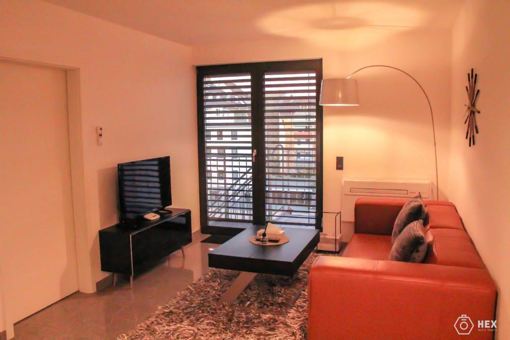 a living room with a red couch and a tv at Bluestone Boarding Apartments in Düsseldorf