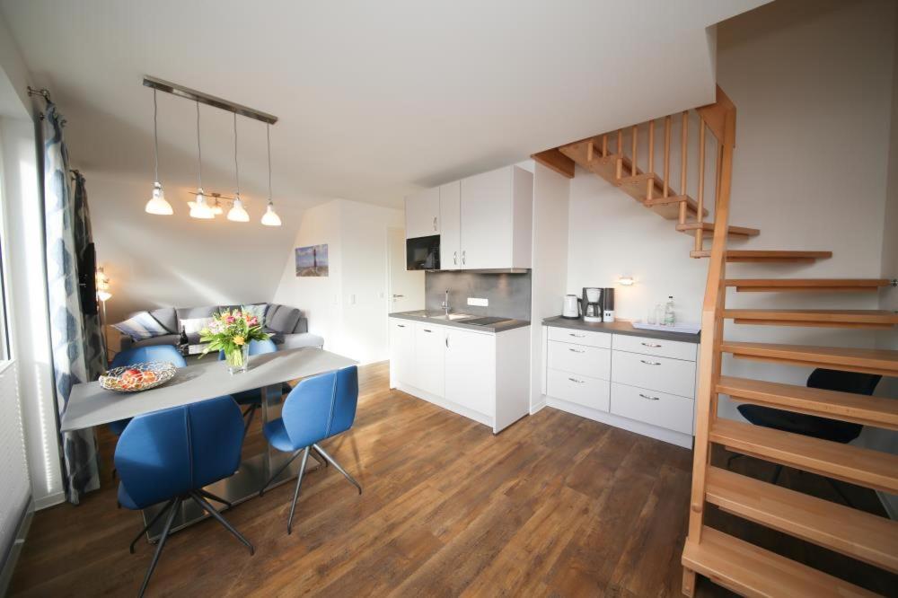 een keuken met een tafel en stoelen en een trap bij Ferienwohnung Windstärke 8 in Scharbeutz