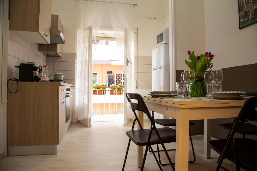 kuchnia ze stołem z kwiatami w obiekcie San Silverio Luxury House w Rzymie