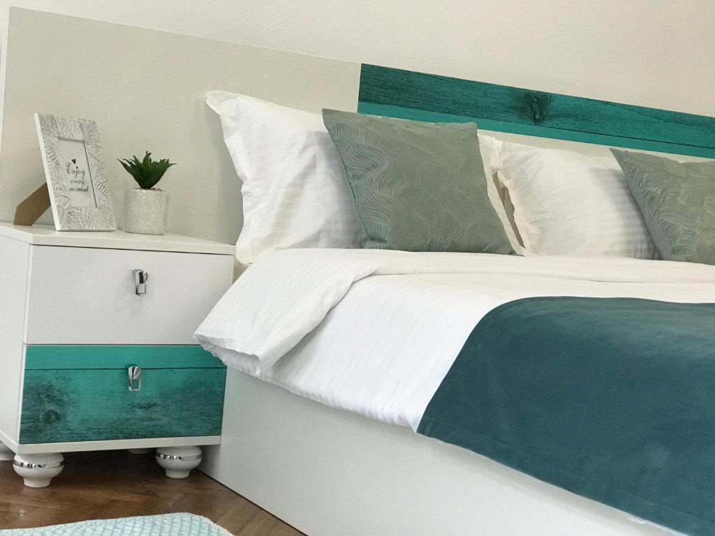 Un dormitorio con una cama con cabecero azul y verde. en 36 Central Residence, en Brasov