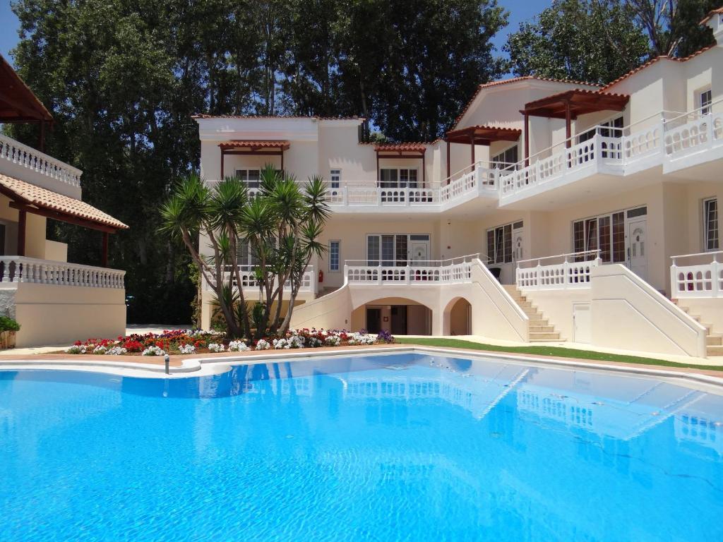 a large swimming pool in front of a villa at Perla Beach in Agia Marina Nea Kydonias