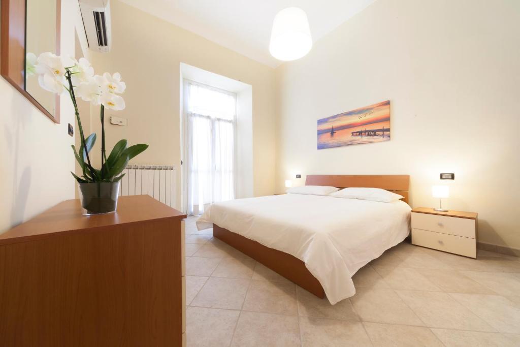 - une chambre avec un lit et un vase de fleurs dans l'établissement IRIS CENTRALISSIMO, à Sanremo
