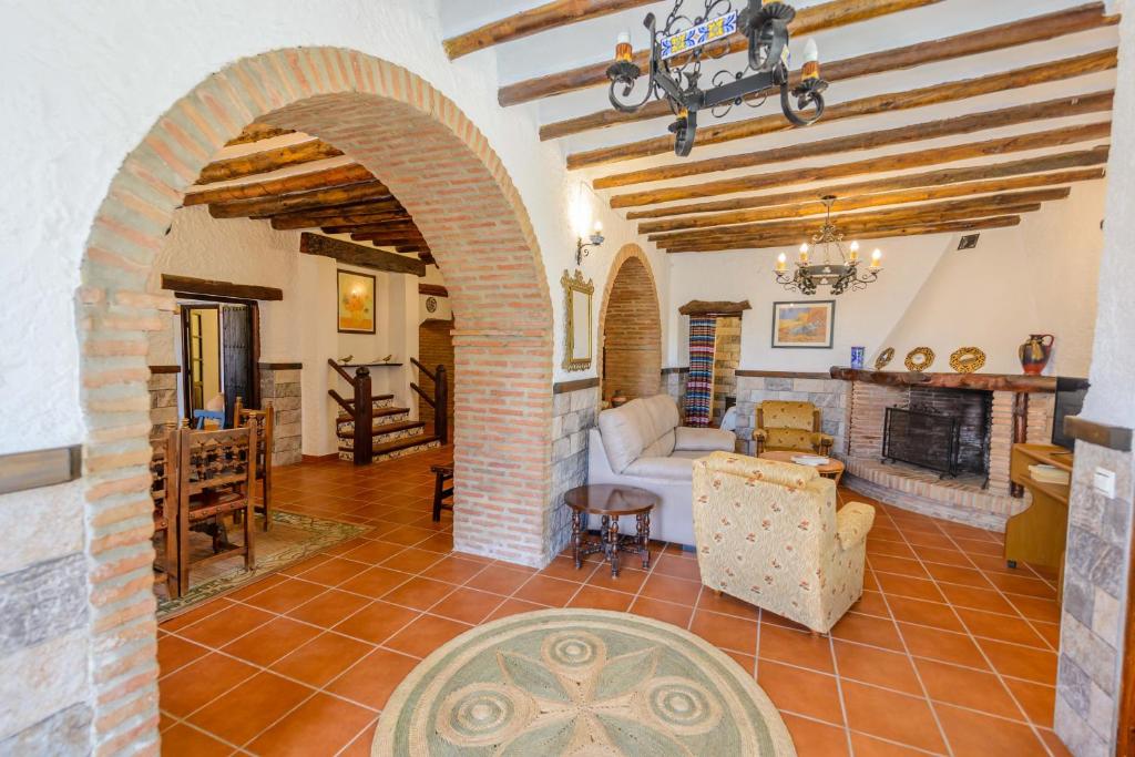 a living room with an archway and a fireplace at Holiday Home El Pilarillo Piscina Compartida in Alcaucín