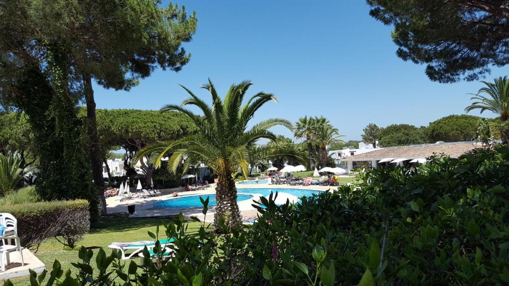 a pool at a resort with palm trees and chairs at P209 Balaia Golf Village in Albufeira