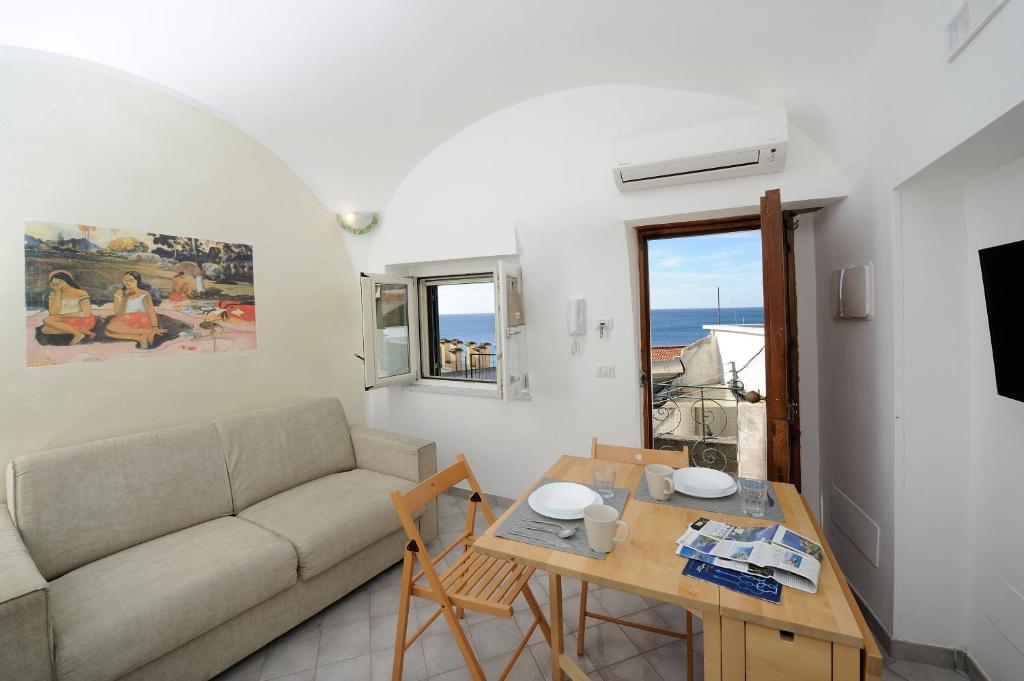 ein Wohnzimmer mit einem Sofa und einem Tisch in der Unterkunft Sol Levante in Amalfi
