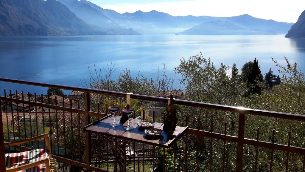 einen Tisch mit Weingläsern auf einem Balkon mit Seeblick in der Unterkunft IseoLakeRental - Casa Anita in Riva di Solto