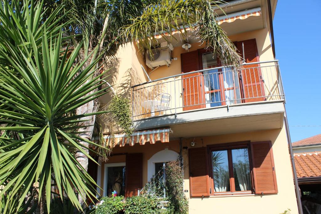 ein Apartmentgebäude mit einem Balkon und einer Palme in der Unterkunft B&B Momentidì in Paestum