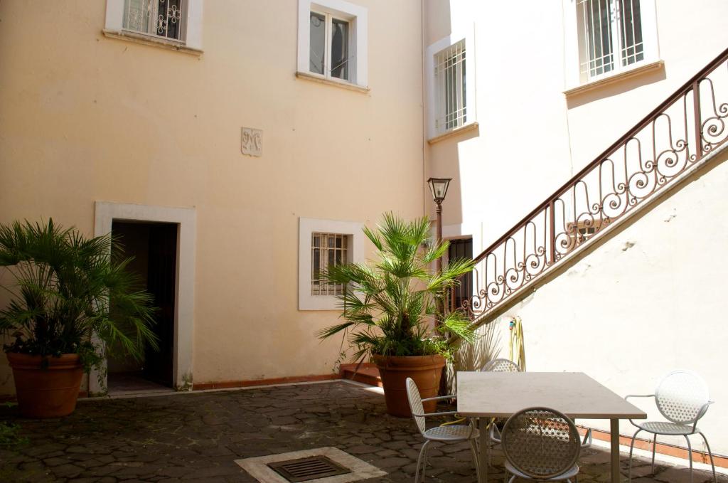 un patio avec une table et des chaises à côté d'un bâtiment dans l'établissement Palazzina Rosa, à Lanciano