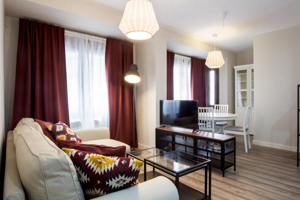 a living room with a couch and a tv at APARTAMENTOS OASIS in Zamora