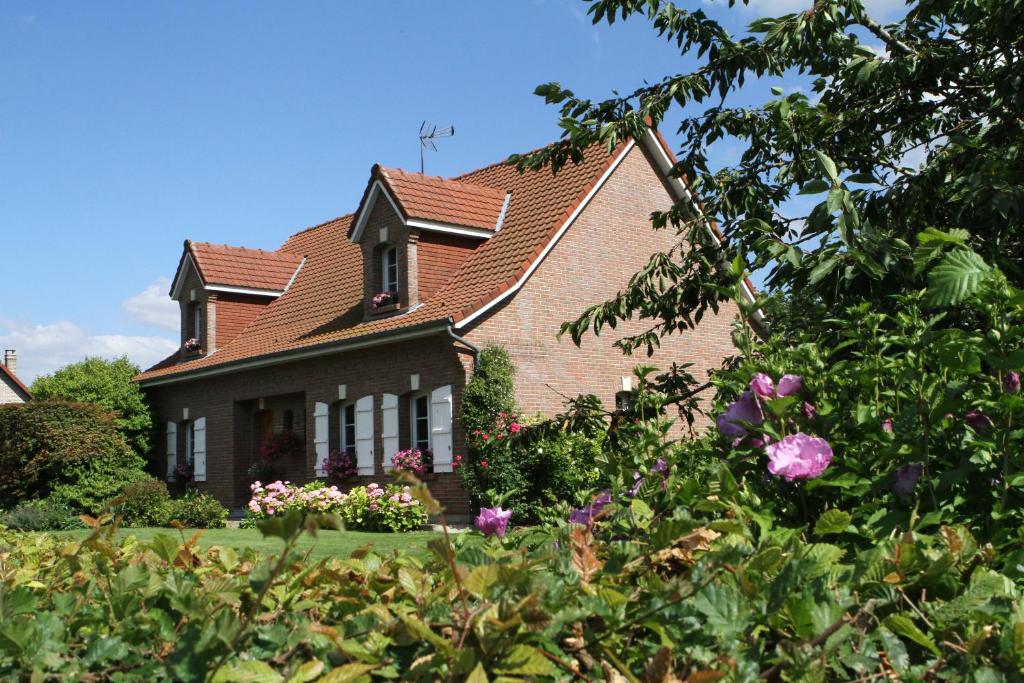 una casa con techo rojo y algunas flores en le logis du scardon en Saint-Riquier