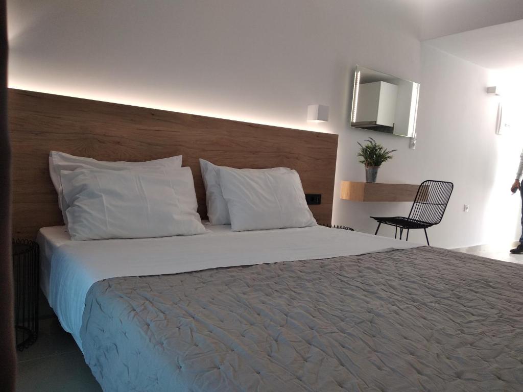 a bedroom with a large bed with white pillows at Aestas Apartments in Agia Marina Nea Kydonias