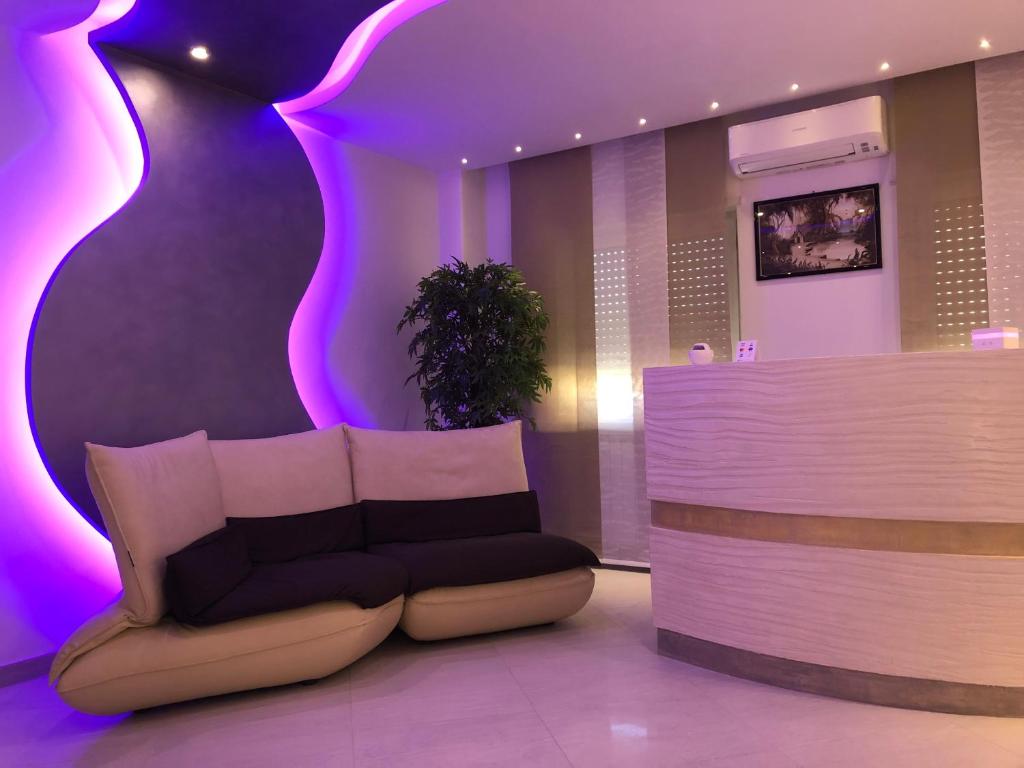 a lobby with a couch and a counter with purple lights at B&B Rossini Luxury in Rende