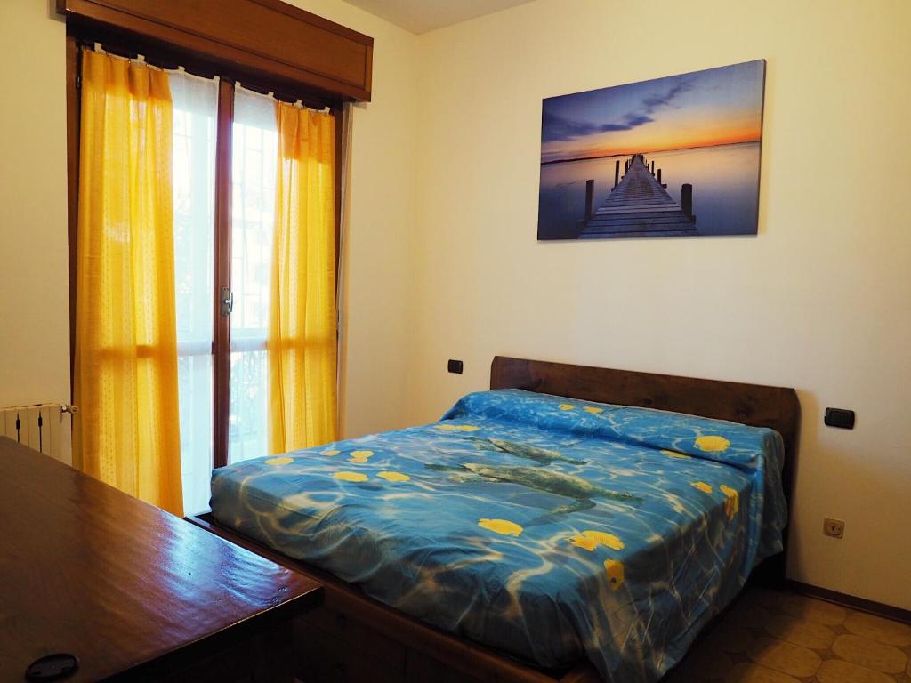 1 dormitorio con cama, mesa y ventana en Casa vacanza Laila en Cassina deʼ Pecchi