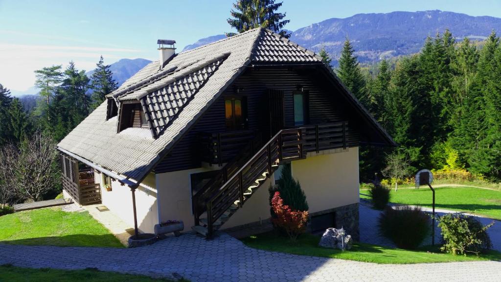 a small house with a wooden roof and stairs at Apartments Jasa in Mozirje