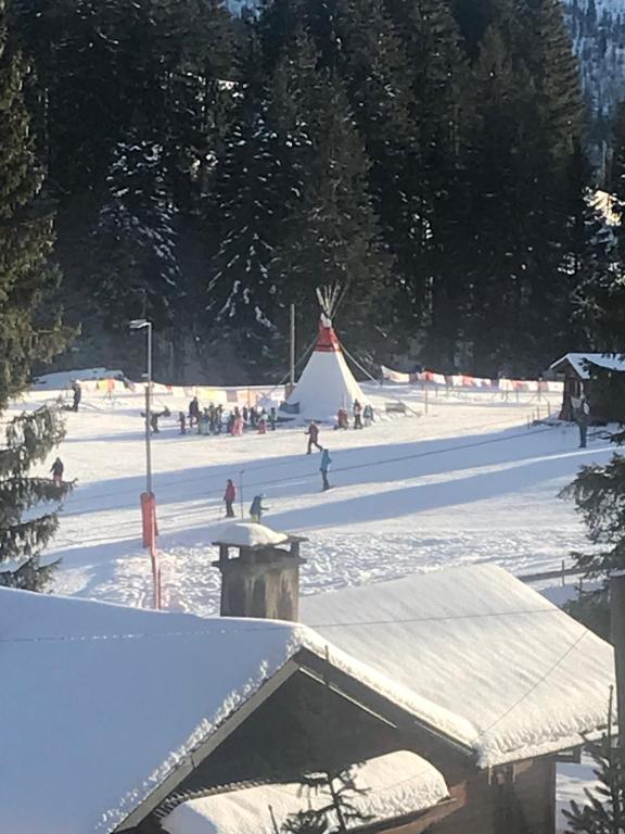 un gruppo di persone nella neve con una tenda di Route des Joncs 300 Appartemen a Les Paccots