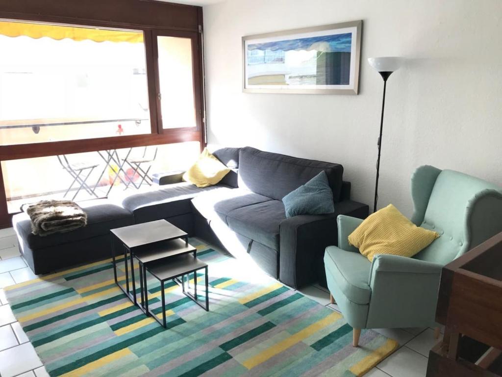 uma sala de estar com um sofá e duas cadeiras em AICE HEGOA avec Parking Inclus em Saint-Jean-de-Luz