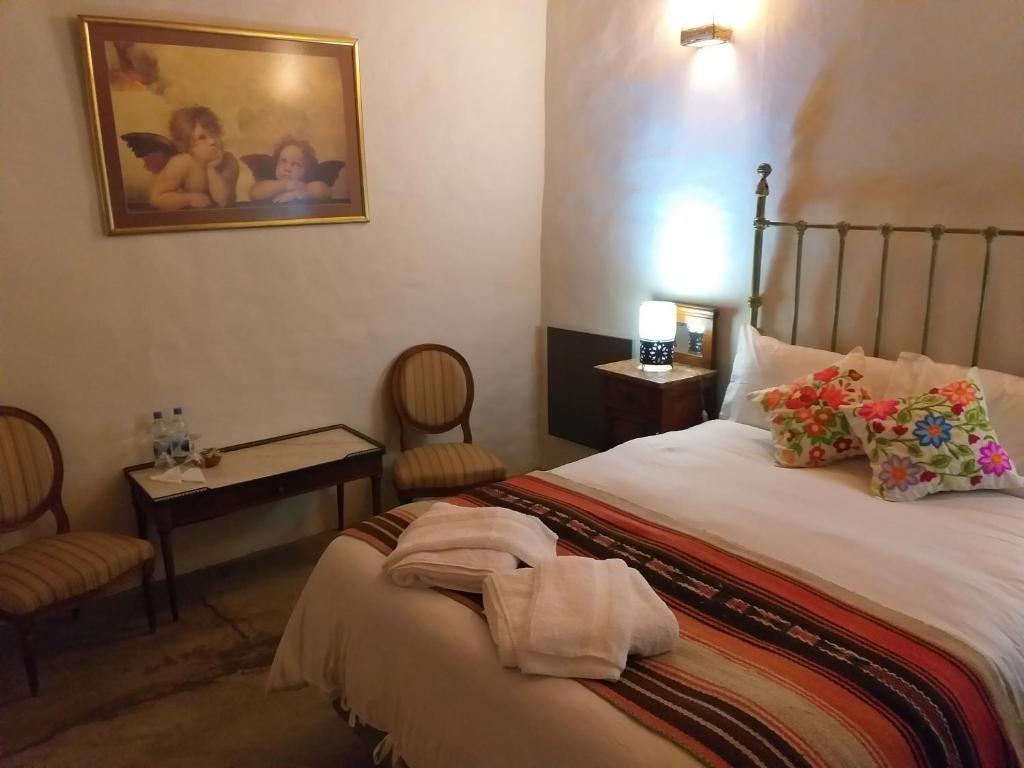 sypialnia z łóżkiem i stołem z krzesłami w obiekcie Sendero De Las Cabras w mieście Purmamarca