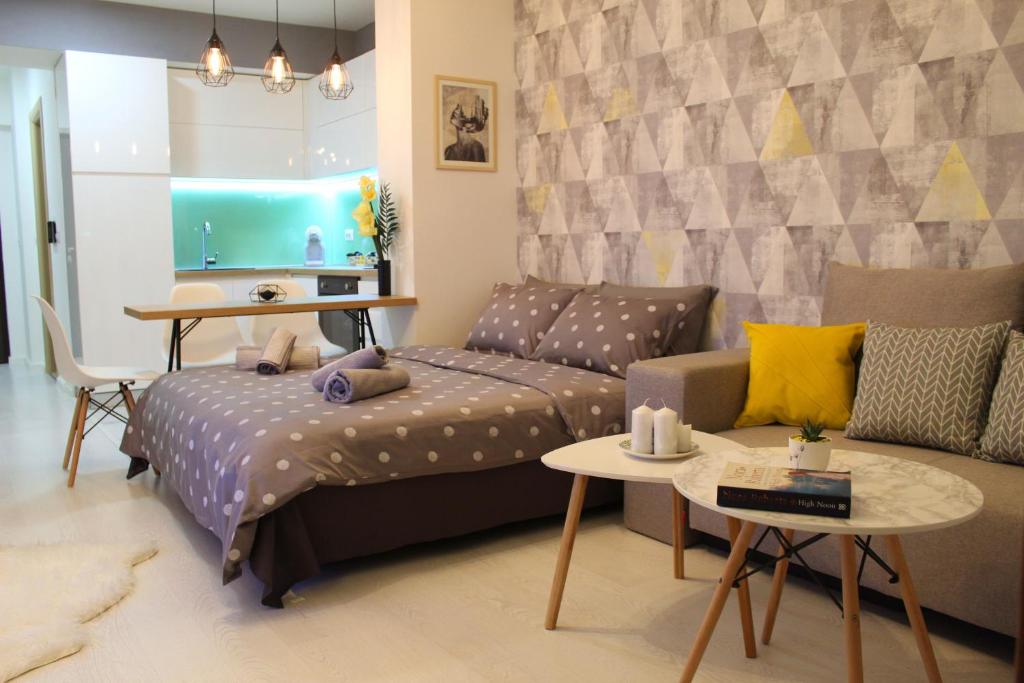 uma sala de estar com um sofá e uma mesa em BS Apartment Flatiron em Skopje