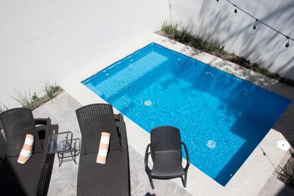 a swimming pool with a group of chairs next to it at Playa Azul Sayulita in Sayulita